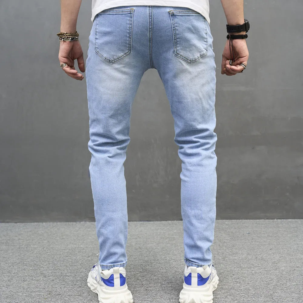 Light blue skinny cotton stretch men's jeans with mid waist and tapered leg on model