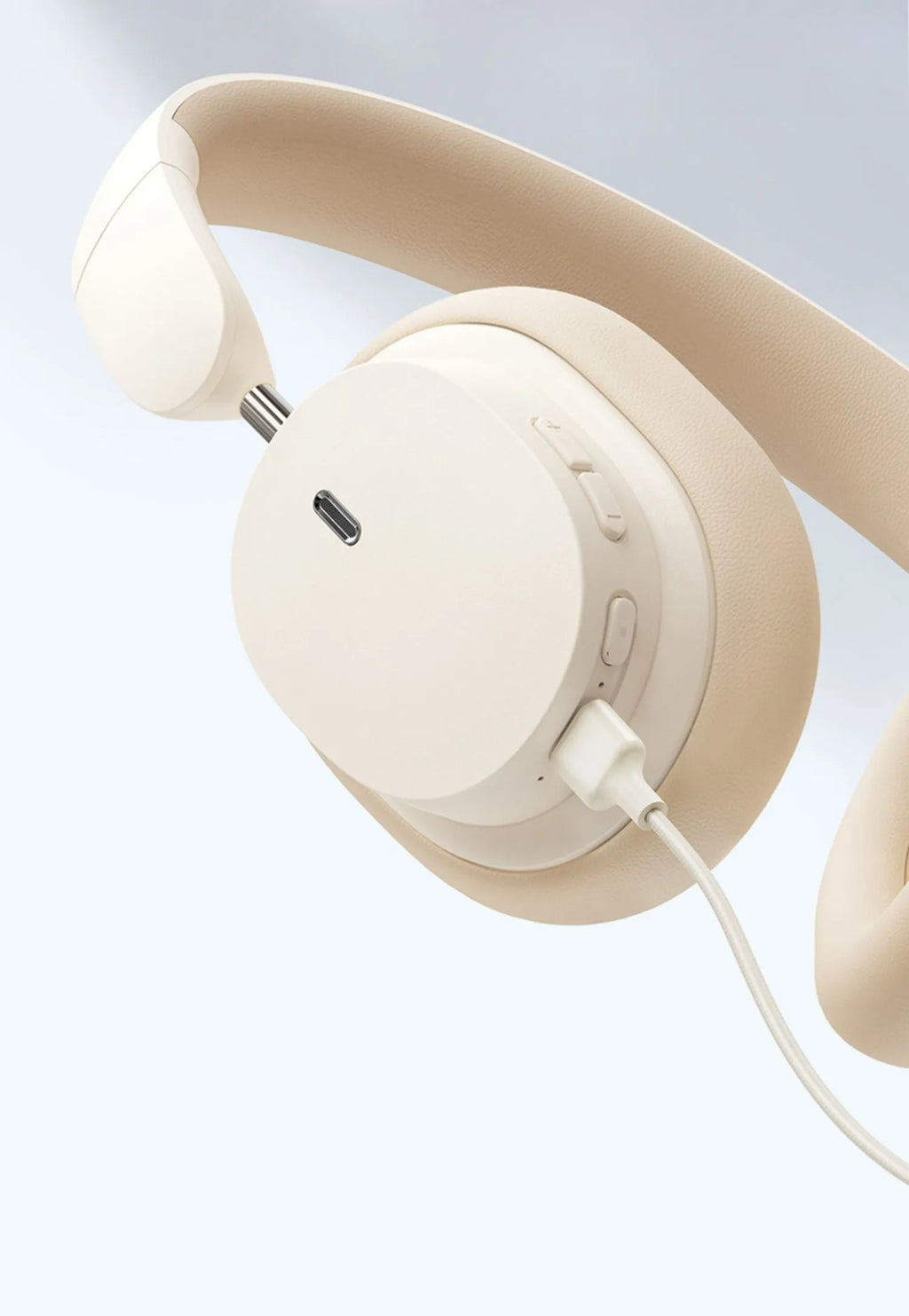 Beige wireless Bluetooth over-ear headphones with a headband, shown with a Type-C charging cable.
