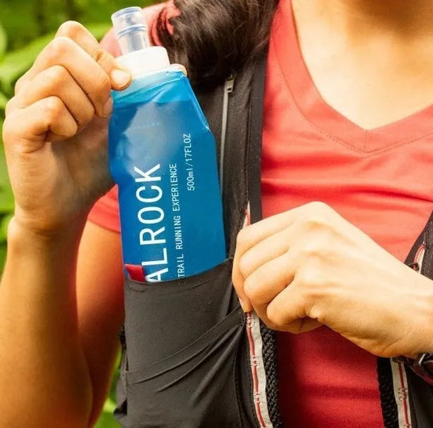 Close-up of a portable plastic drinking straw with bite valve, shown next to a sports bottle cap.