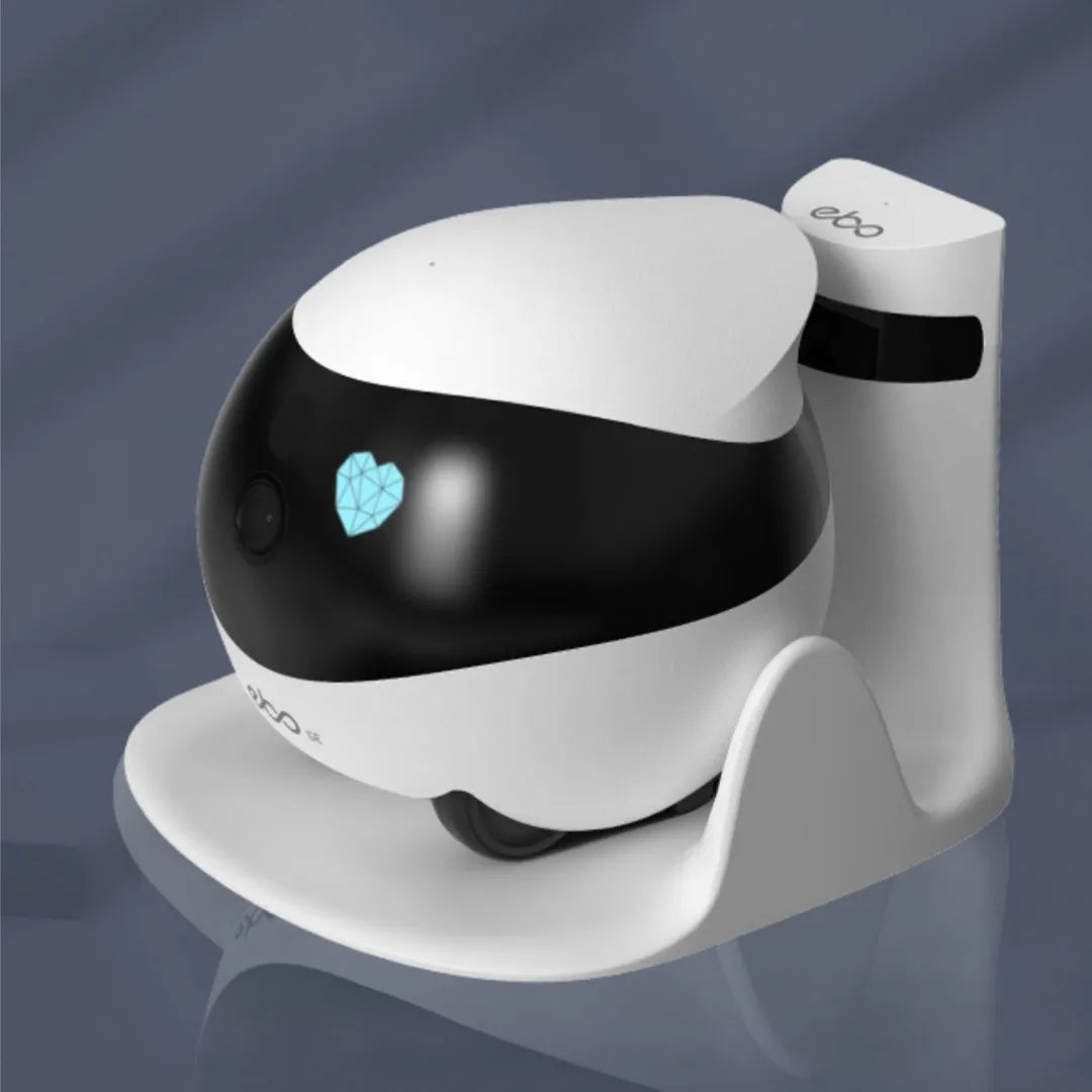 White smart home mobile robot camera on a charging dock.