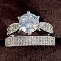 A geometric white gold-coloured alloy wedding ring bracelet on a finger, showing its continuous band design with a round detail.