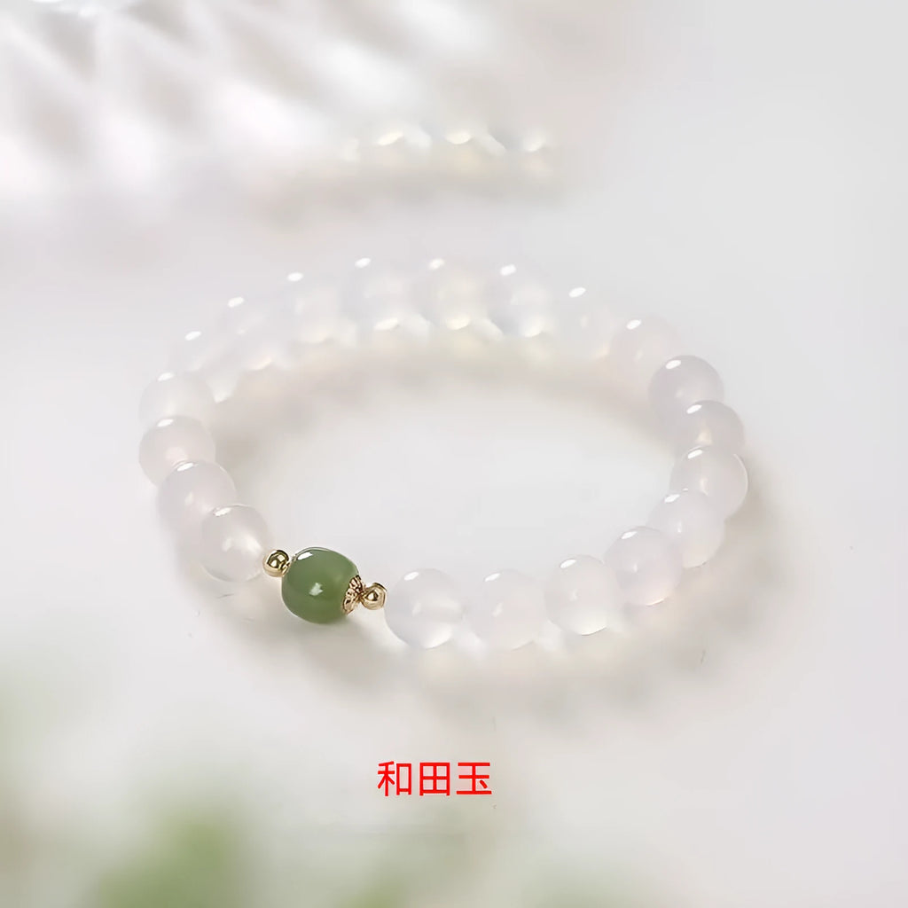 Handmade white agate and crystal bracelet with cinnabar inlay, showing text design on beads