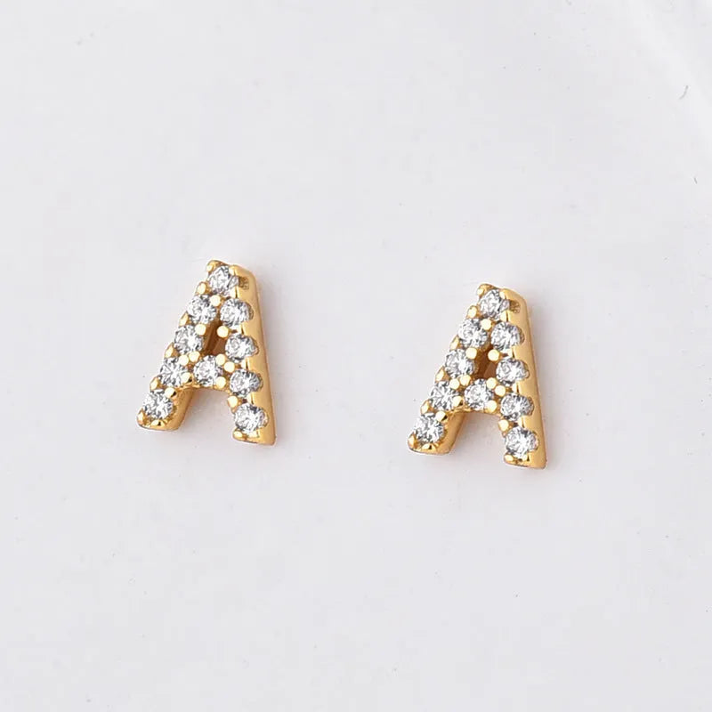Gold plated brass earring in the shape of the letter A, set with a sparkling zircon stone.