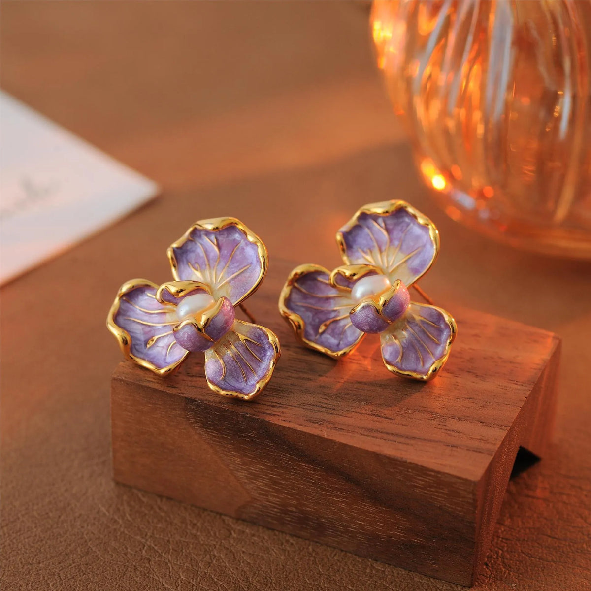 Purple copper alloy flower-shaped women's earrings with dripping oil finish on a plain background