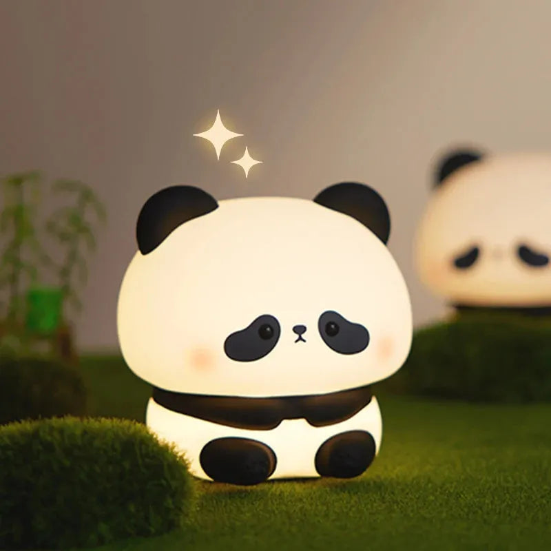 Cute panda LED night light with soft silicone cover, USB rechargeable, featuring colourful lighting modes on a bedside table.
