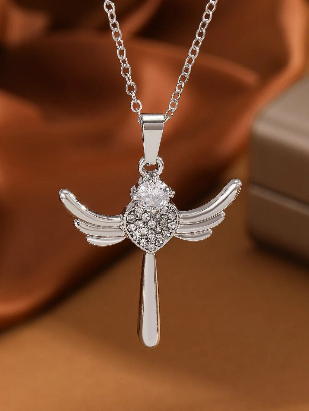 Silver heart-shaped angel wings pendant clavicle chain necklace with cross elements on display