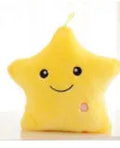 Colourful glowing five-pointed star plush pillow on a dark background, illuminated from within.