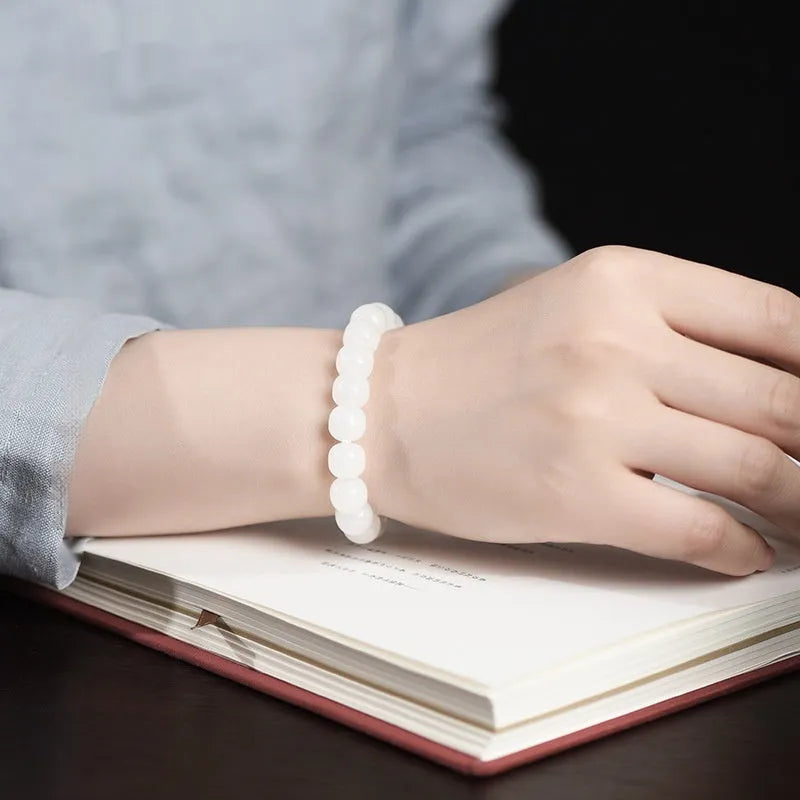 A white Hetian jade barrel bead bracelet showing three size options on a neutral background.