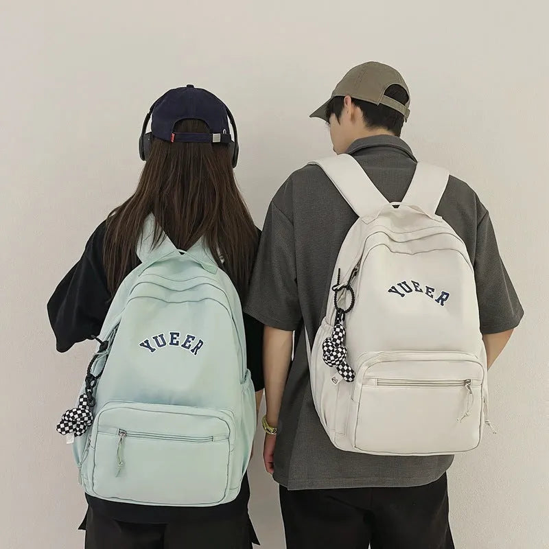 Simple nylon backpack for women, 32cm, with computer pocket, in five colours including black, blue, red, white, and light green.