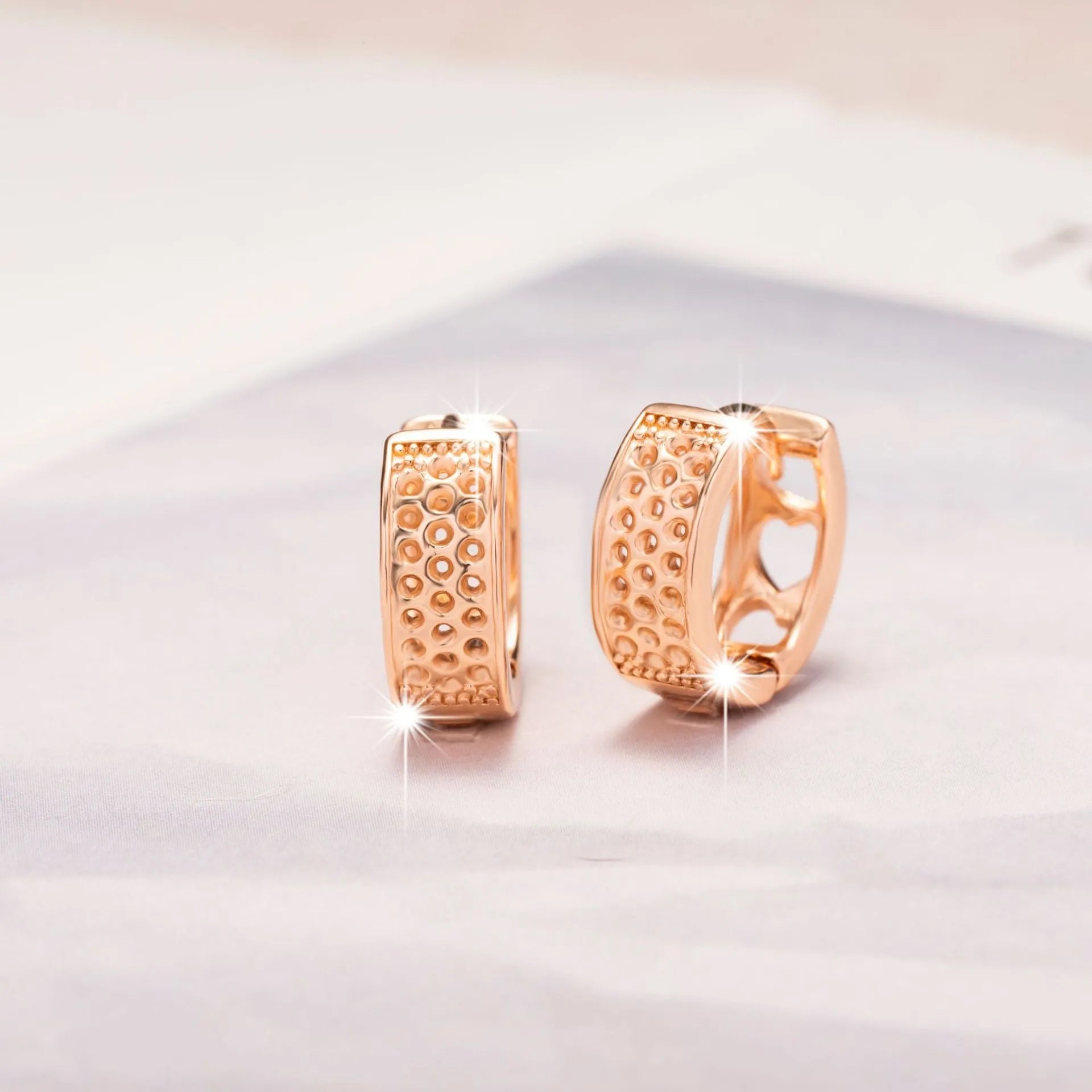 Rose gold women's earrings with a hollow heart shape featuring three cut-out sections.