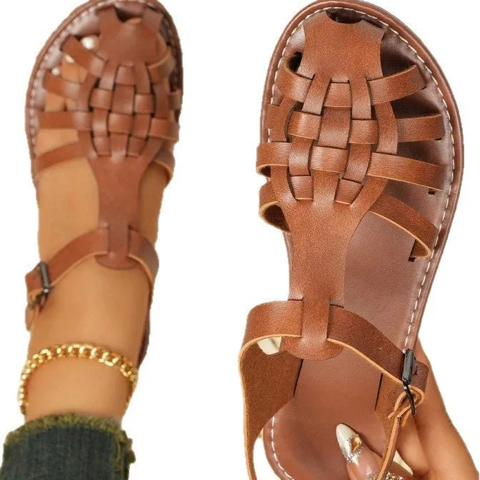 Dark brown women's Roman sandals with woven PU upper and buckle closure on a rubber sole.