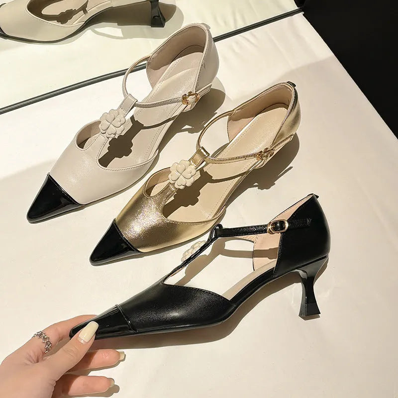 Women's black stiletto heel sandals with pointed toe, flower buckle, and shallow mouth opening.