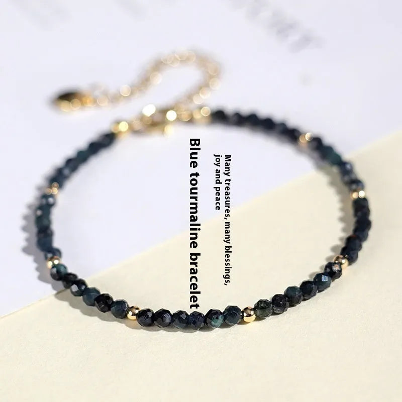 Blue tourmaline bracelet with 3mm beads and silver spacer beads on wrist