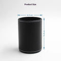 Round black leather pen container on a desk holding pens and pencils.