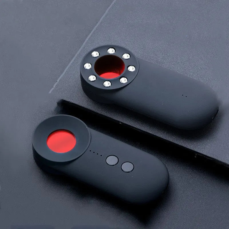 Black portable anti-car GPS and wifi signal detector with a USB cable on a table.