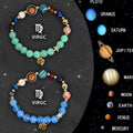 Two natural stone beaded bracelets with zodiac charms on a wooden surface.