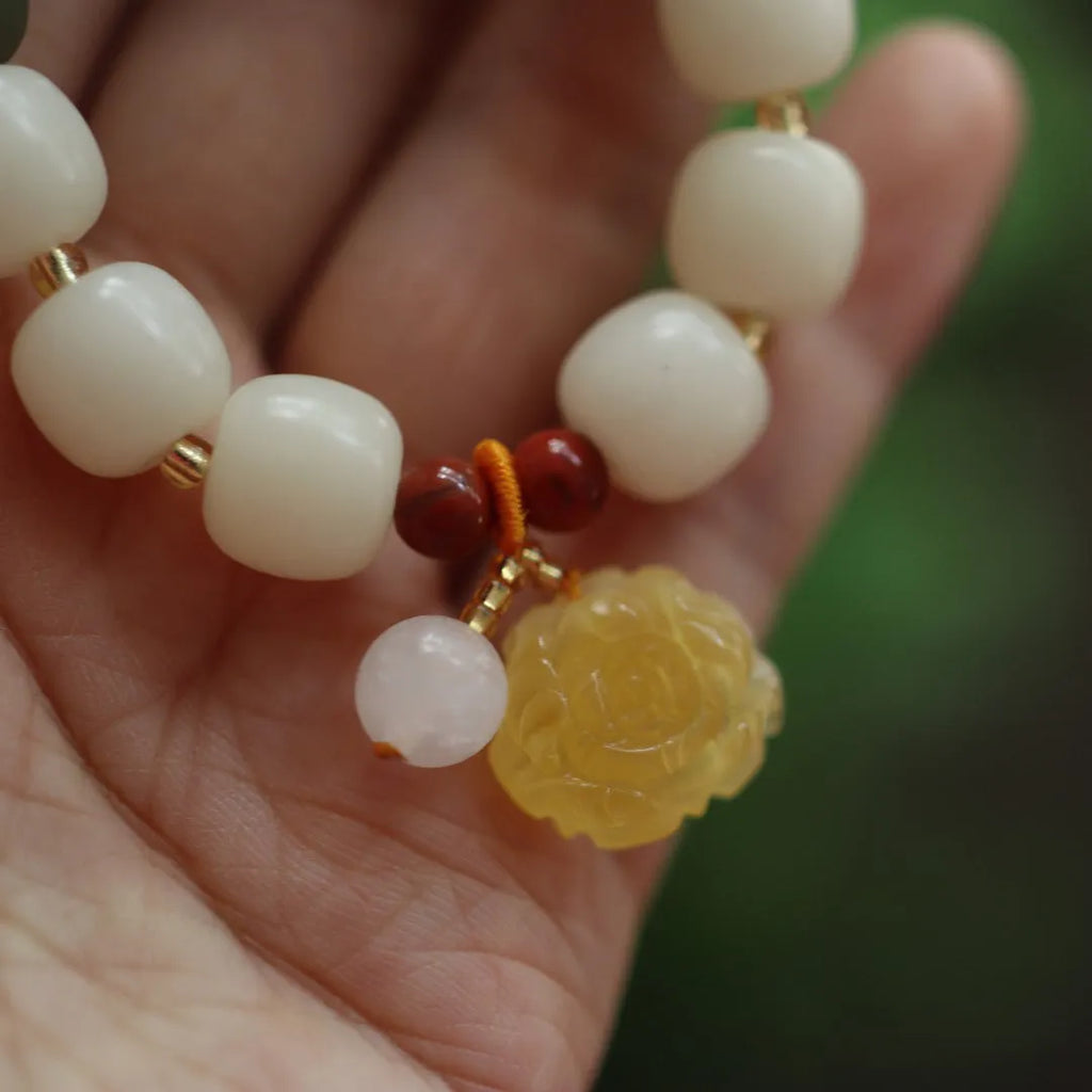Woven bodhi bracelet with gradient white jade beads and natural beeswax lotus pendant on wrist