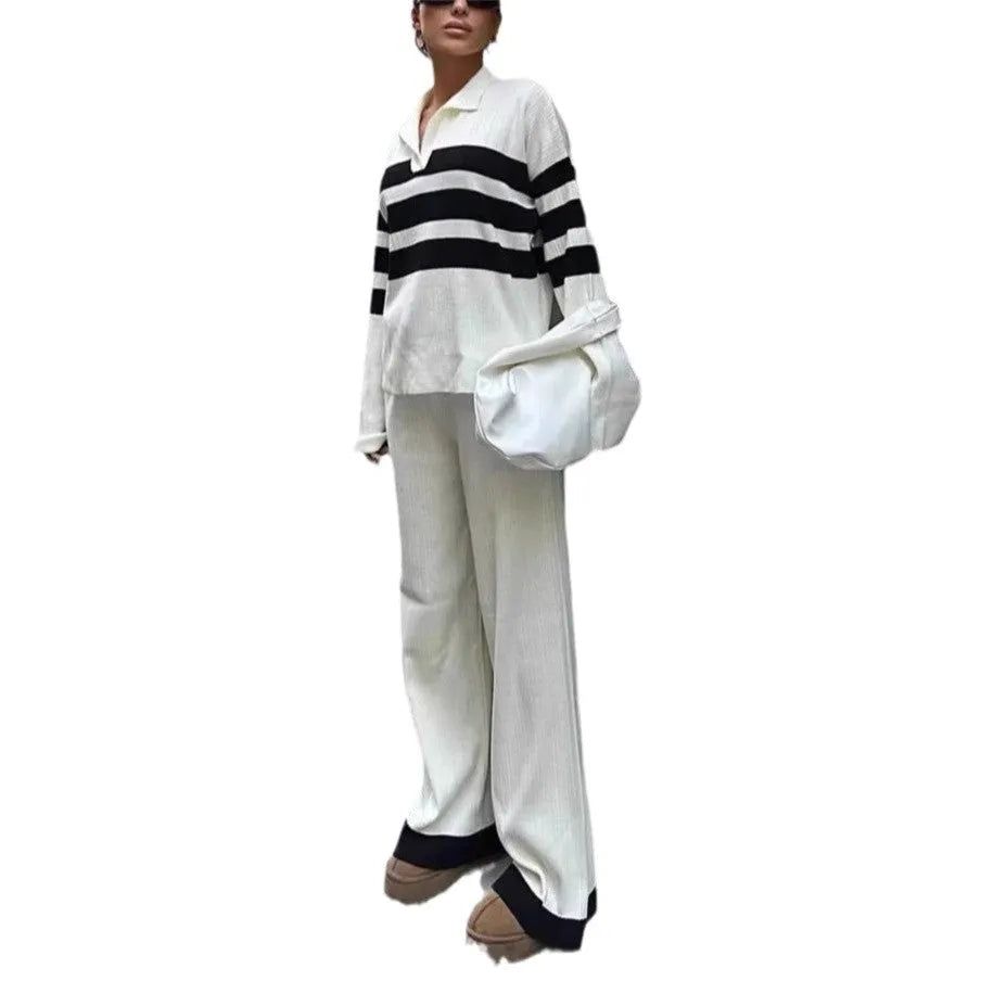 Women's black and white striped knitted polo shirt with long sleeves paired with matching trousers.