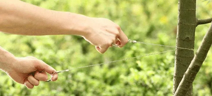 Outdoor survival hand wire saw with leather case, showing coiled stainless steel cutting line.