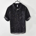 Mens loose-fit black polo shirt with a short sleeve and a V-neck lapel collar on a hanger.
