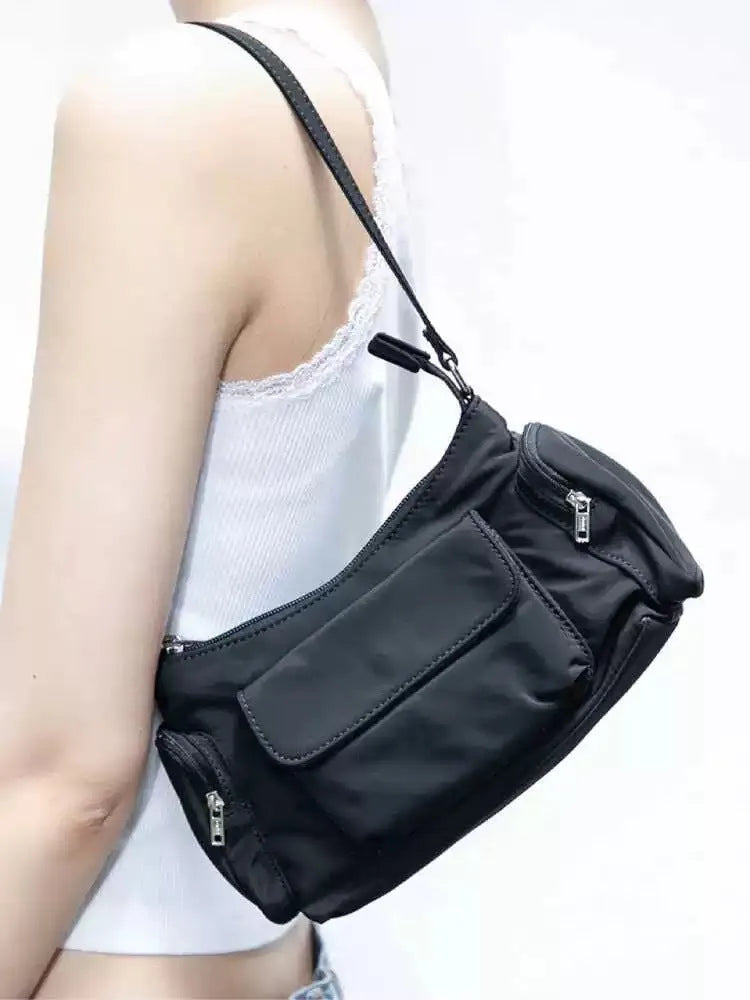 Simple black lightweight nylon shoulder bag with double pockets showing side line detailing