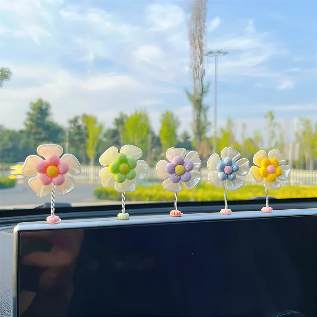 Small colourful plastic swing ornament for car dashboard, shown in multiple colour options.