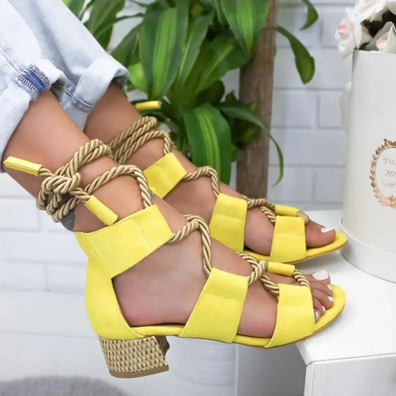Women's beige suede sandals with a thick middle heel, fish mouth toe, and front ankle straps.