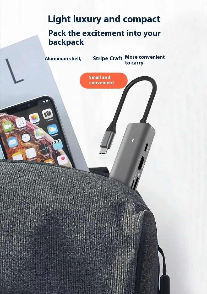 LQT-LH07 7-in-1 USB-C card reader and computer hub on a desk next to a laptop.