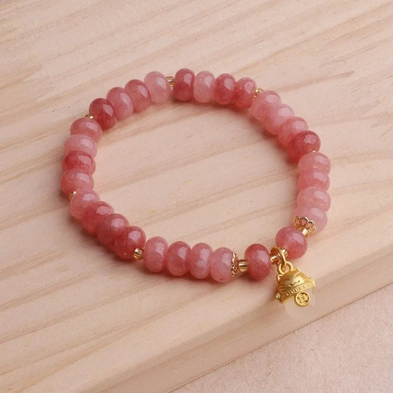 Women's retro strawberry quartz bracelet with lucky cat charm on wrist