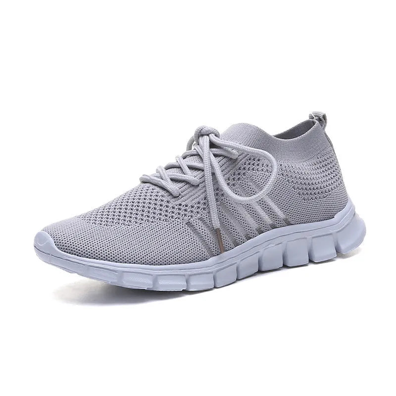 Beige ladies flying knit flat shoes with mesh upper, round toe, and low heel on a plain background