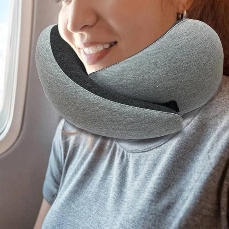Navy blue memory foam U-shaped travel neck pillow rolled up next to its carry bag