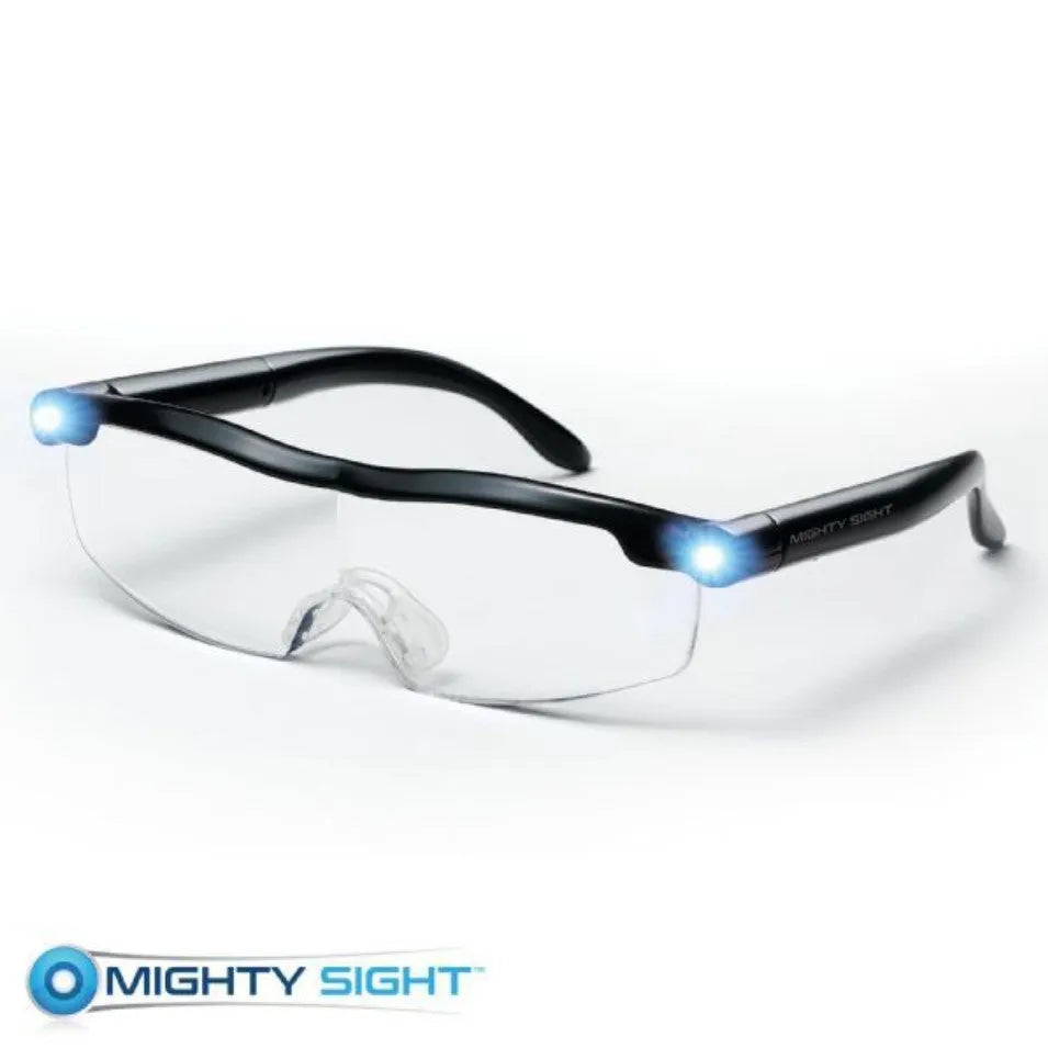 Transparent black USB LED light reading glasses on a table, showing the integrated light and frame.