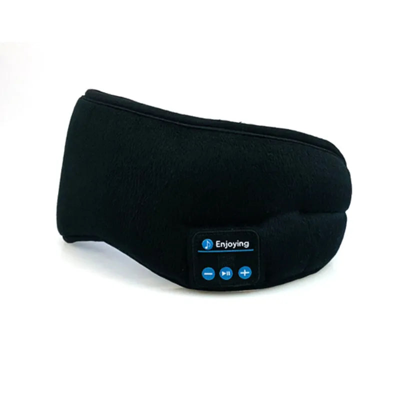 Soft satin sleep eye mask in black with adjustable strap lying flat on a light background