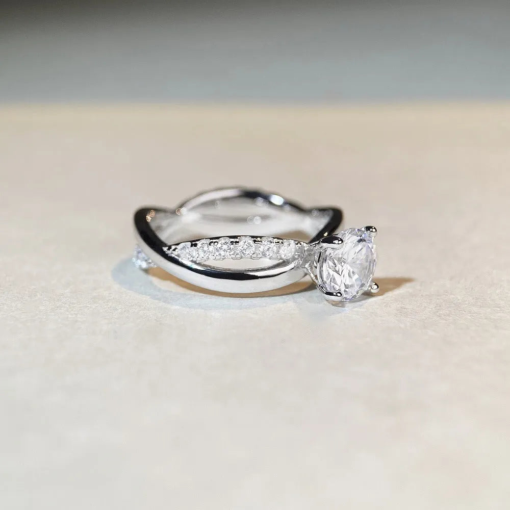 Silver ring with twisted geometric band and a 1 karat moissanite in a four-claw setting.