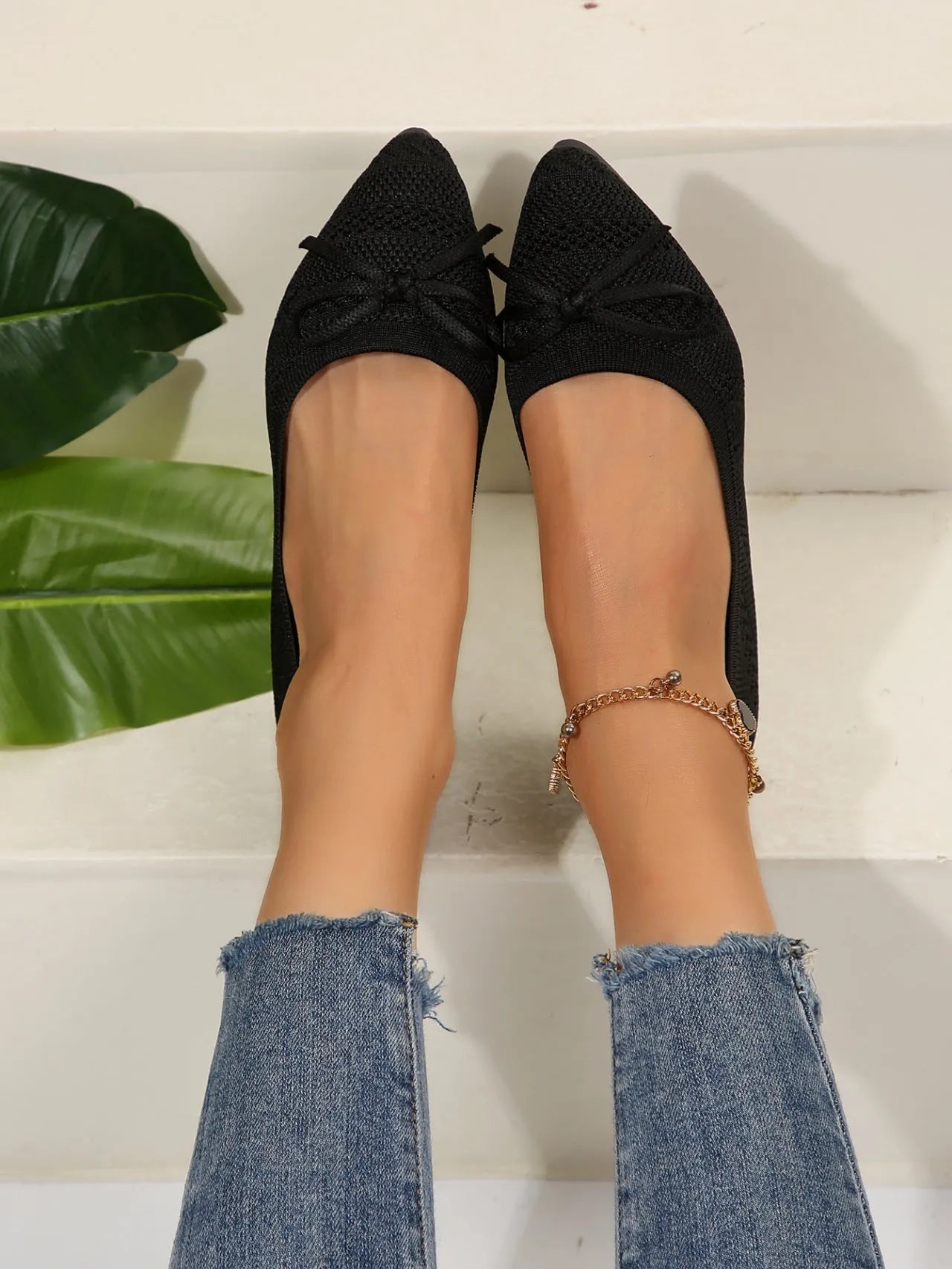 Women's blue knitted loafers with a bow detail and pointed toe on a flat rubber sole.