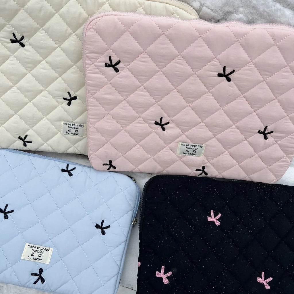 White nylon laptop bag with a light blue embroidered rhombus bow on the front