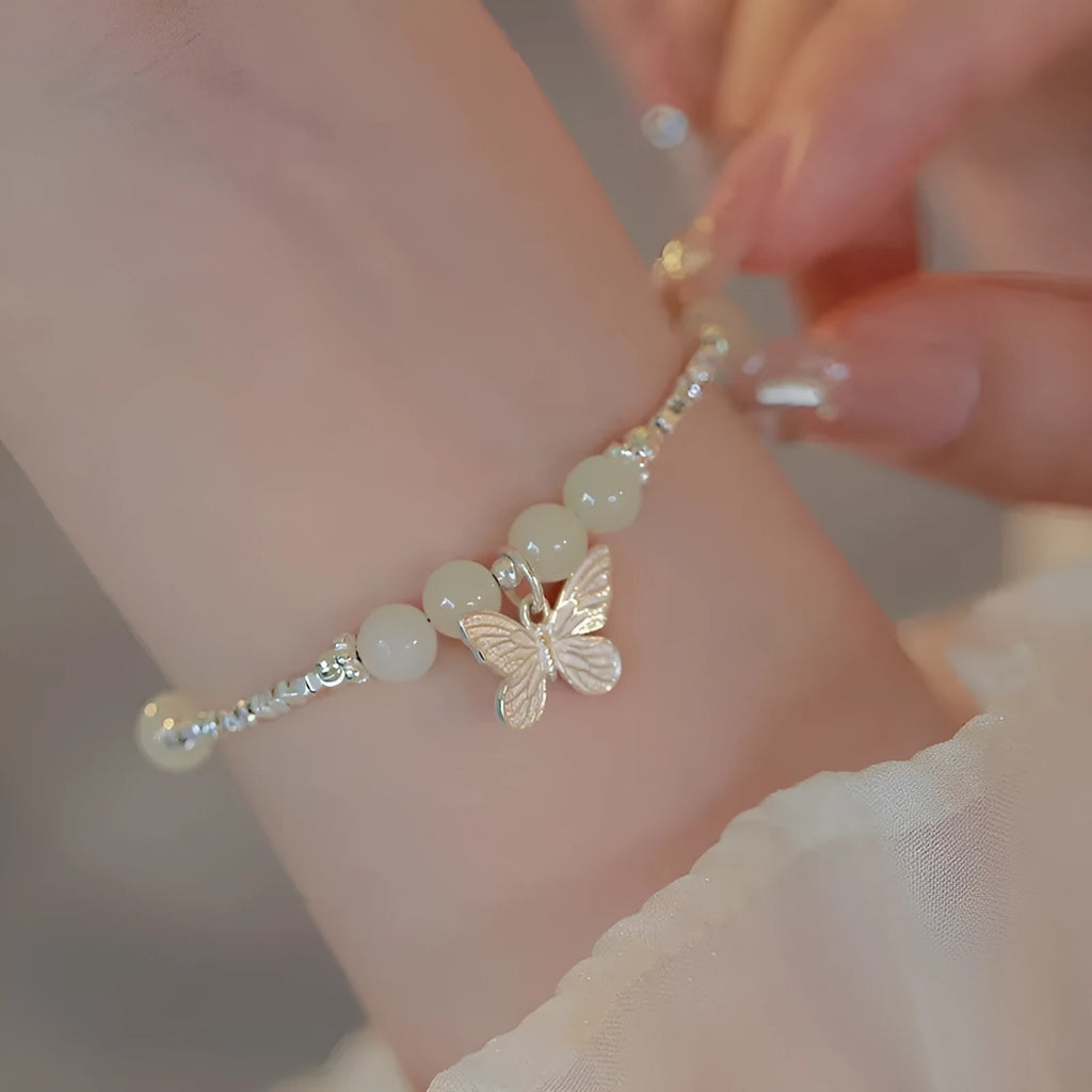 Women's copper butterfly jewellery set with electroplated silver finish, showing bracelet and necklace