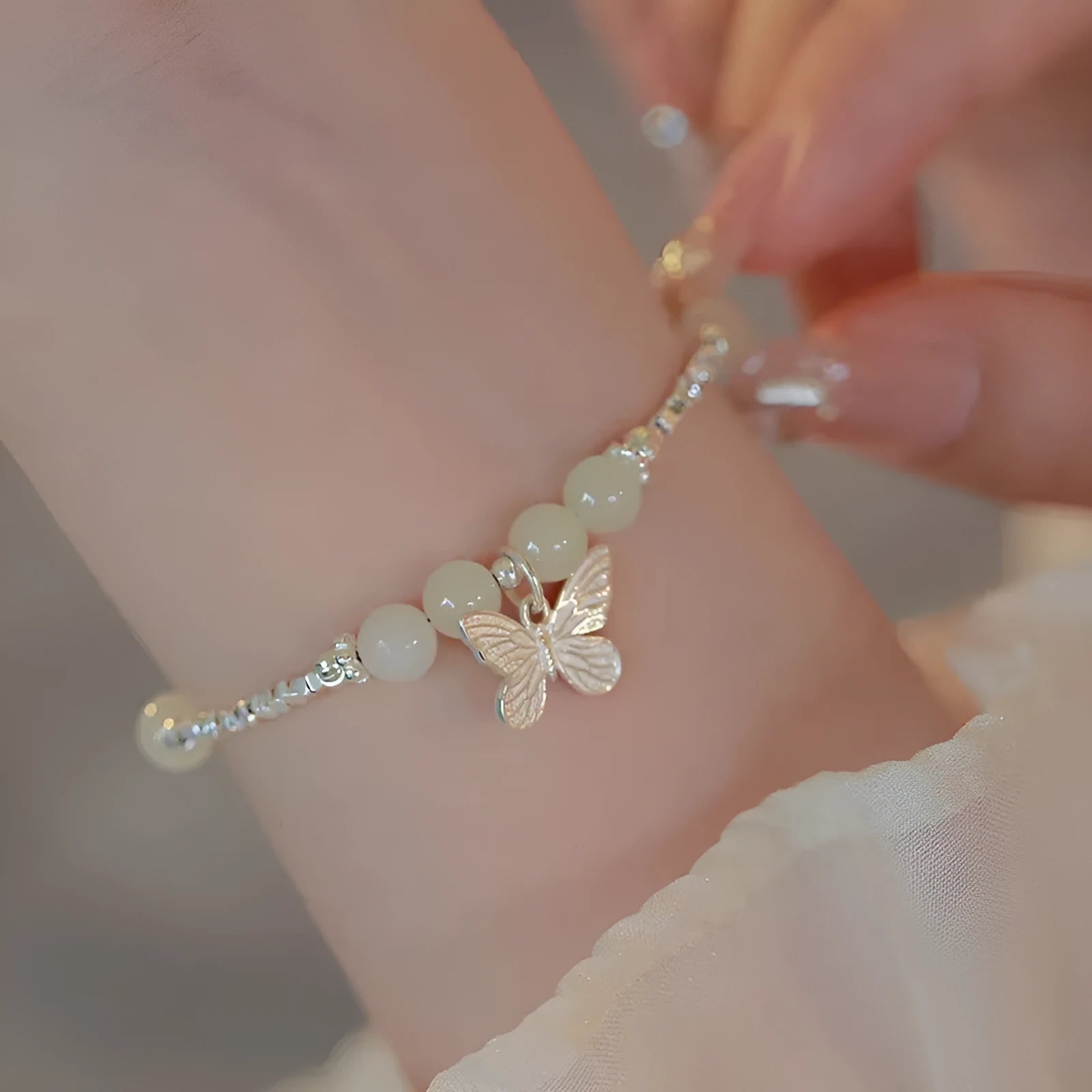 Women's copper butterfly jewellery set with electroplated silver finish, showing bracelet and necklace
