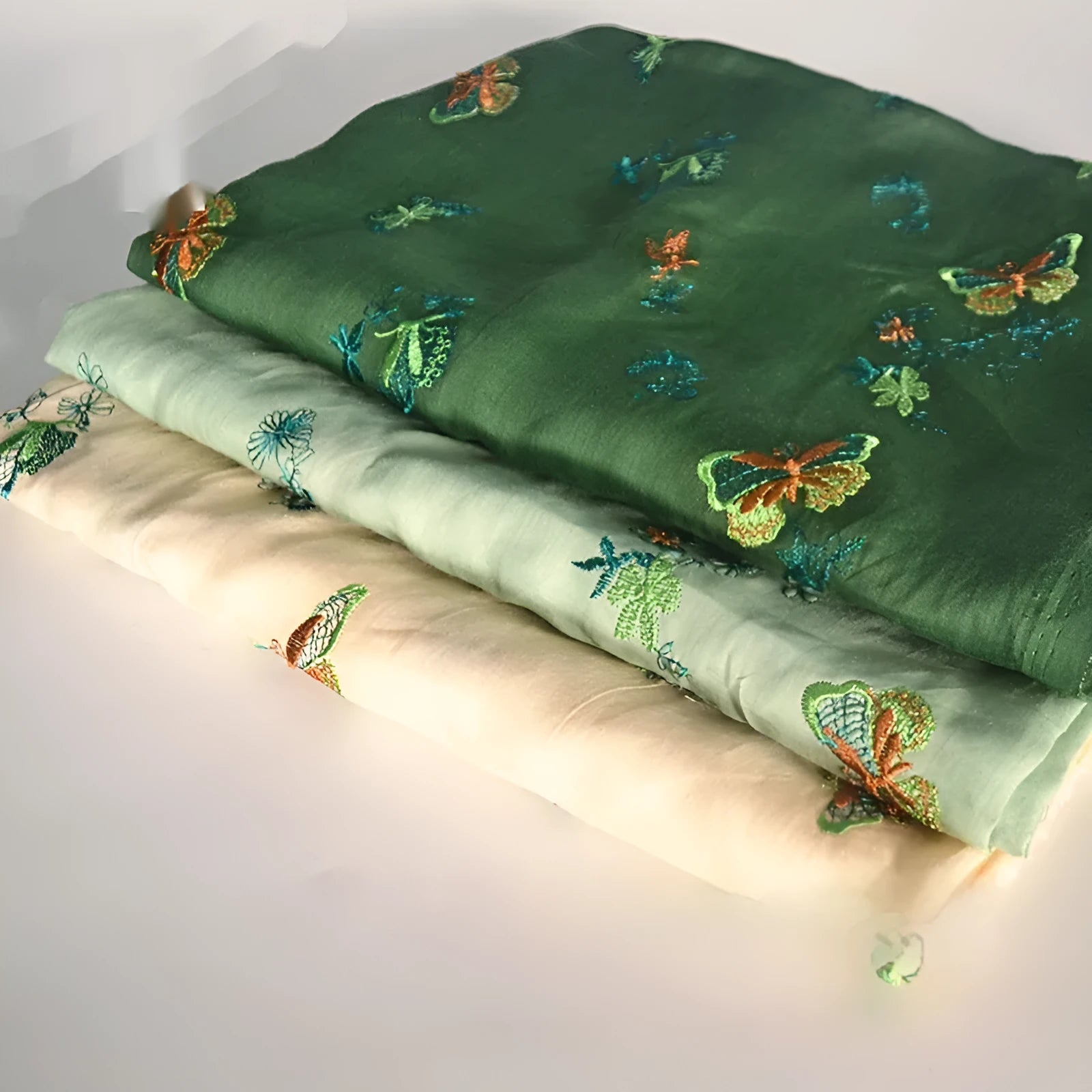 Pure ramie fabric swatch in beige, dark green, and grass green colours showing texture.