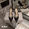 Black pointed toe patent leather women's stiletto heels with pearl decoration on the heel.