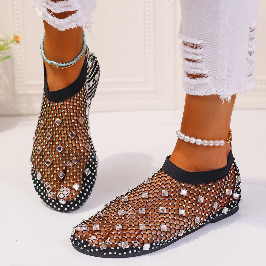 Colourful rhinestone detail on women's white mesh flat sandals with a rubber sole.