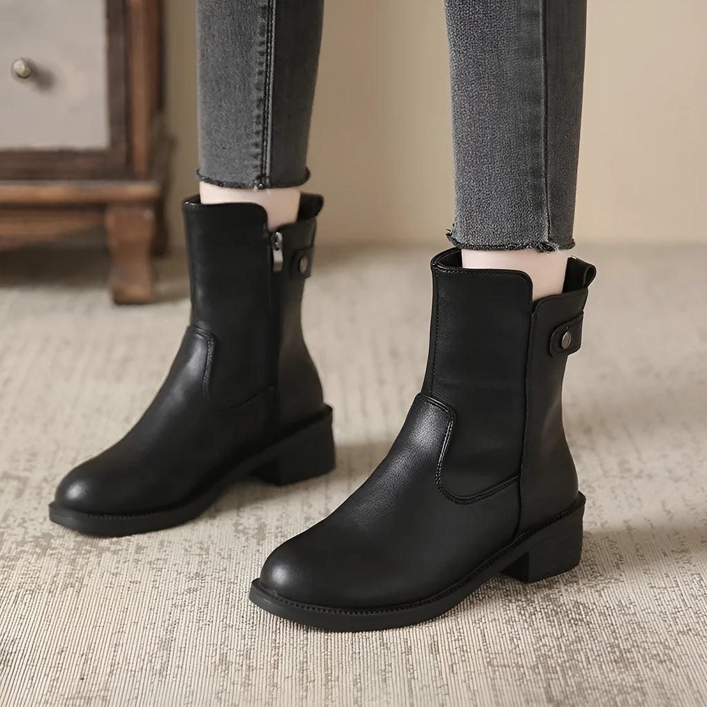 Black women's low heel ankle boots with side zip closure and round toe on a rubber sole.