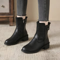 Black women's low heel ankle boots with side zip closure and round toe on a rubber sole.