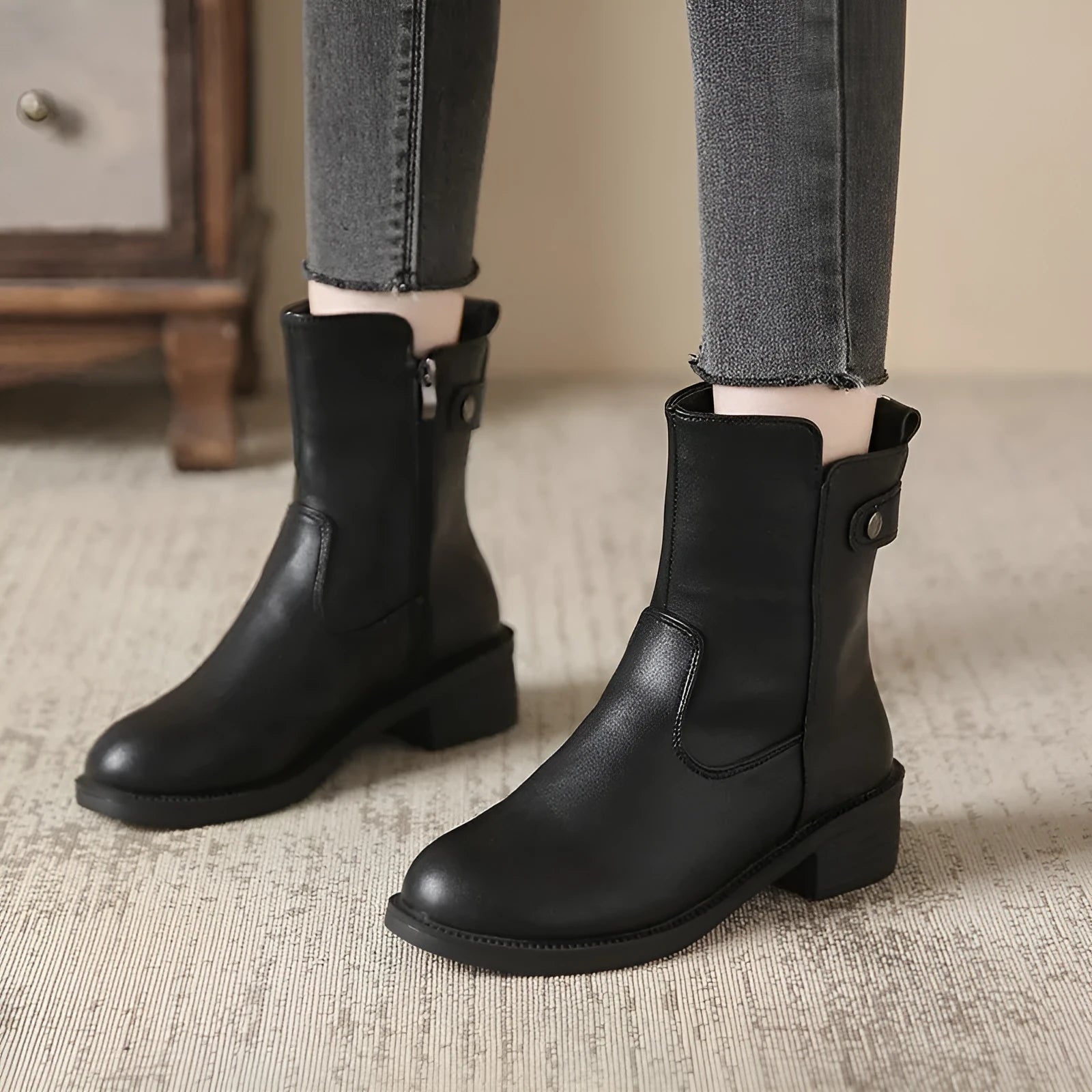 Black women's low heel ankle boots with side zip closure and round toe on a rubber sole.