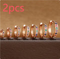 Circle-shaped perforated stud earrings in gold, rose gold, and silver colours on a white background.