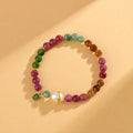 Close-up of a chalcedony bracelet with geometric 6.5mm beads in a tourmaline colour on a wrist.