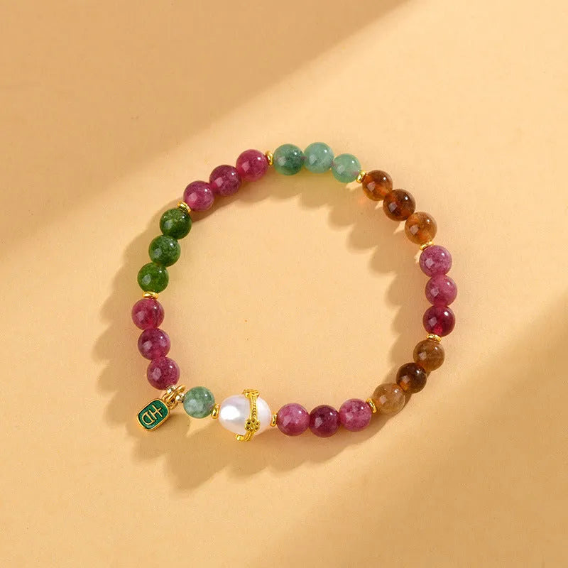 Close-up of a chalcedony bracelet with geometric 6.5mm beads in a tourmaline colour on a wrist.