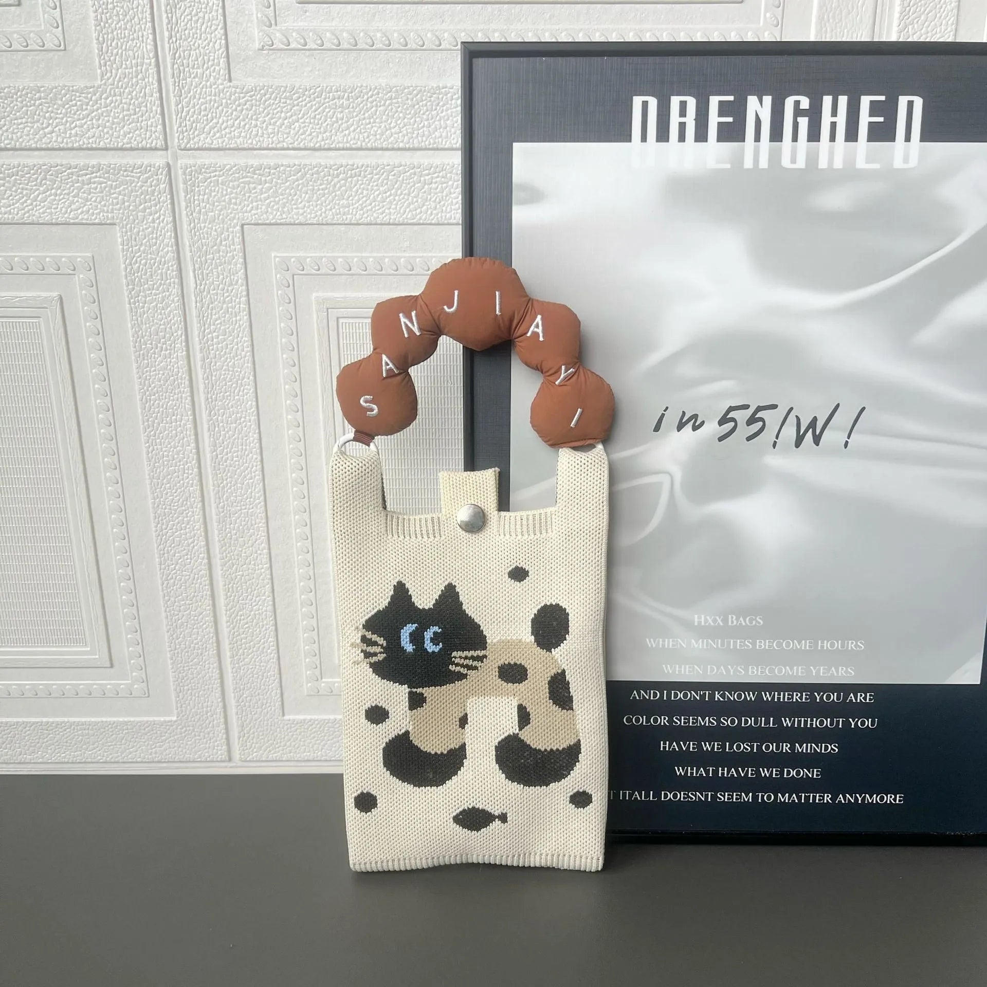 Square vertical cartoon knitted messenger bag with woven polyester construction and internal phone pocket
