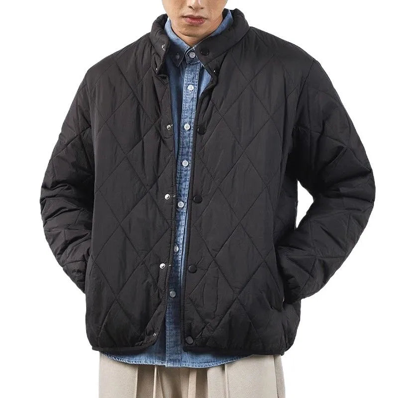 Men's black diamond lattice quilted winter jacket showing lengthened silhouette and loose fit