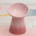 White high-foot ceramic pet bowl with slanted rim on a non-slip base for dogs and cats.